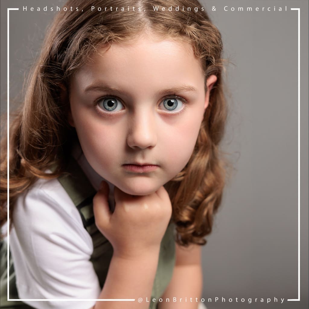 Professional headshot of a child with captivating blue eyes, capturing innocence and charm