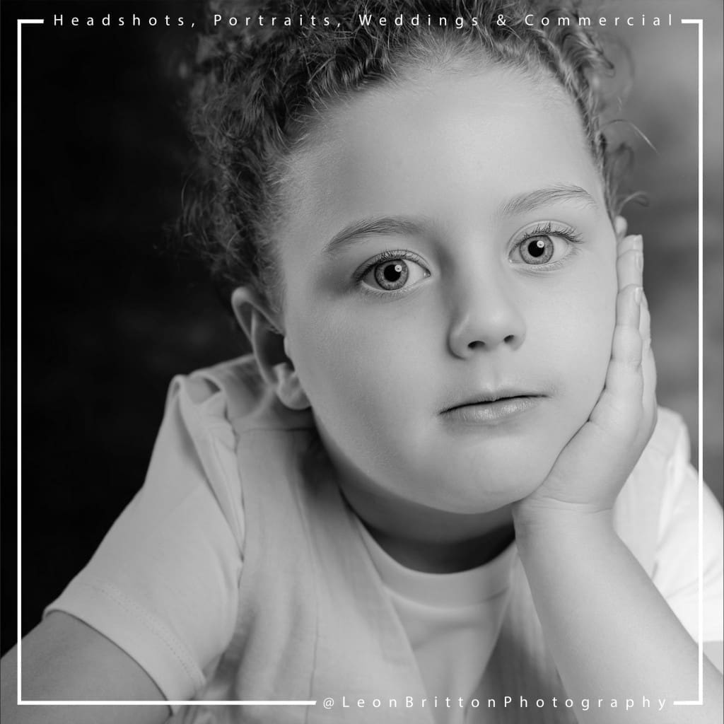 Black and white portrait of a young girl with a thoughtful expression, highlighting her natural beauty