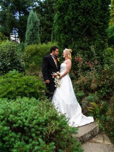 Bride and groom holding hands and looking at each other during a quiet moment away from wedding guests