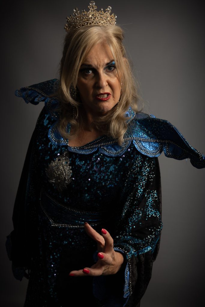 Cath Rice as the Wicked Queen reaching toward camera, Slay Belles promotional portrait